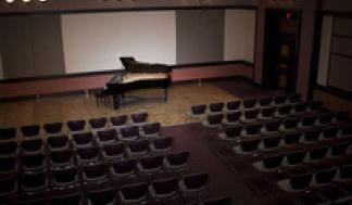 Piano on stage in an empty concert hall