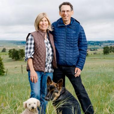 Photo: Arthur and Sandra Reidel standing outdoors together with their dogs